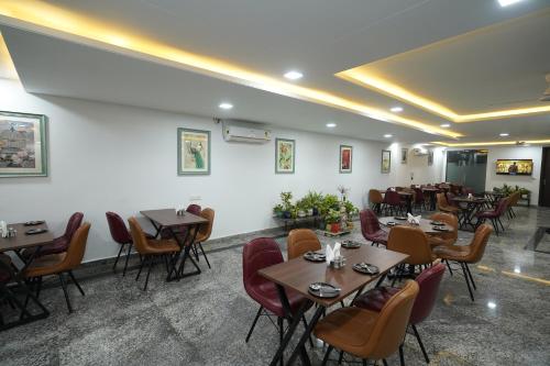 een restaurant met tafels en stoelen in een kamer bij Posh Garden Inn Artemis Hospital Road Gurgaon in Gurgaon