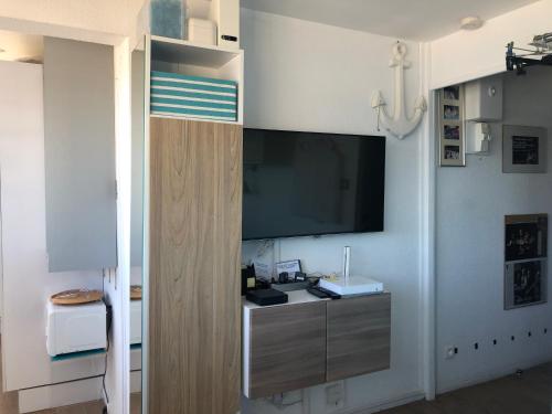 un salon avec une télévision à écran plat sur un mur dans l'établissement Studio Bord de Mer et VUE sur MER WIFI OFFERT, à La Seyne-sur-Mer