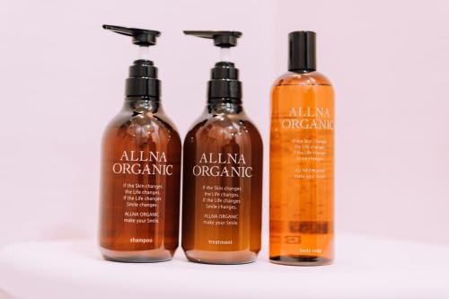 four bottles of allian organic shampoo and conditioner on a table at Yuzawa Onsen Lodge 1min to LIFT House in Seki