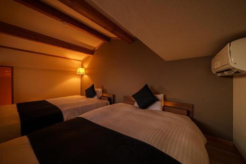 a hotel room with two beds in a room at Chachamaru no Oyado - Vacation STAY 85728 in Yufuin