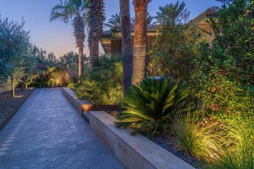 a garden with palm trees and a walkway at Minareto in Siracusa