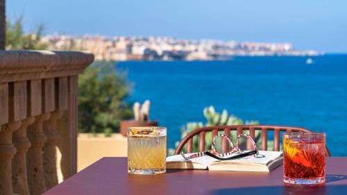 a purple table with two glasses and a book on it at Minareto in Siracusa