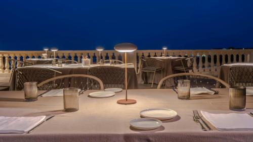 a table with white plates and a lamp on it at Minareto in Siracusa