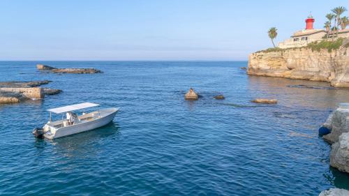 a small boat in the water near a rocky coast at Minareto in Siracusa