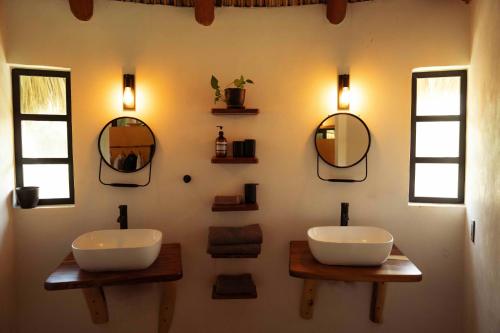 a bathroom with two sinks and mirrors on the wall at Villas Oasis, Troncones in Troncones