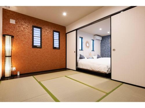 1 dormitorio con 1 cama y puerta corredera de cristal en BEPPU NO YU SORA - Vacation STAY 87966 en Beppu