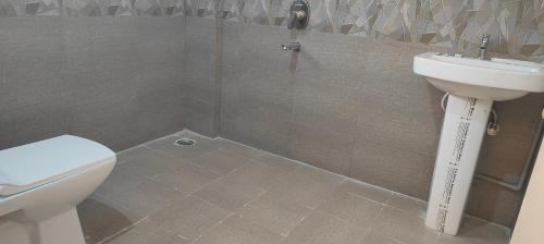 a bathroom with a toilet and a sink at Hotel Amulya Regency in Bengaluru
