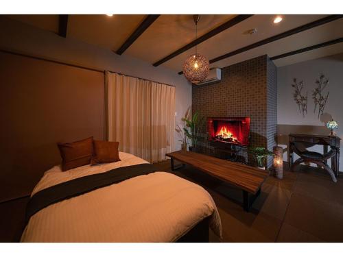 a bedroom with a bed with a fireplace in it at YUHUROTEN YOJYOU NO BI - Vacation STAY 87032 in Yufuin