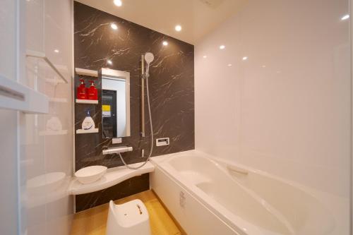 a bathroom with a tub and a sink and a toilet at Takanoya Hoshi - Vacation STAY 91923 in Yufuin