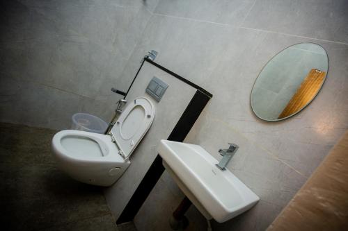 a bathroom with a sink and a toilet and a mirror at THE PARK AVENUE HOTEL - Business Class Hotel Near Central Railway Station Chennai Periyamet in Chennai