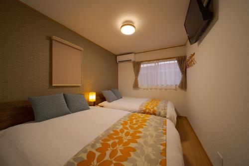 a small bedroom with two beds and a window at Takanoya Tsuki - Vacation STAY 91942 in Yufuin