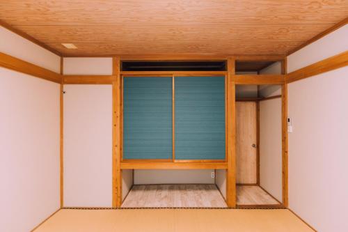 a room with a blue window in a house at Yuzawa Onsen Lodge 1min to LIFT House in Seki