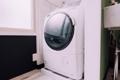 a washing machine in a kitchen next to a window at Yuzawa Onsen Lodge 1min to LIFT House in Seki