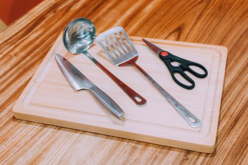 a wooden cutting board with utensils on a table at Yuzawa Onsen Lodge 1min to LIFT House in Seki