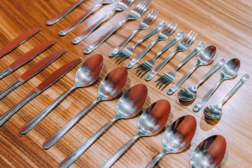 a group of spoons and forks on a wooden table at Yuzawa Onsen Lodge 1min to LIFT House in Seki