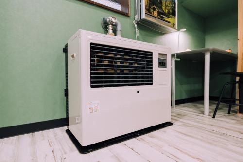 a white air conditioner sitting on top of a wall at Yuzawa Onsen Lodge 1min to LIFT House in Seki