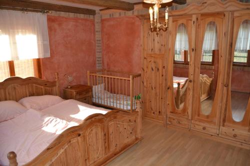 Un dormitorio con una gran cama de madera y una lámpara de araña. en chalupa u Pinkasů, en Střítež