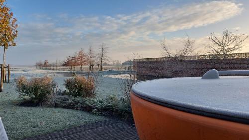 a winter view of a river with a brick wall at Landhuis Eikenburg in Ypres