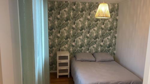 um pequeno quarto com uma cama e um candeeiro em Jolie appartement proche bords de Loire em Orléans