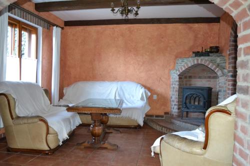 a living room with a fireplace and a table and chairs at chalupa Stritez in Střítež