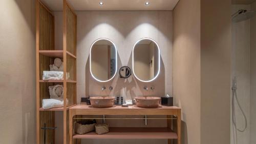 a bathroom with two sinks and two mirrors at Minareto in Siracusa