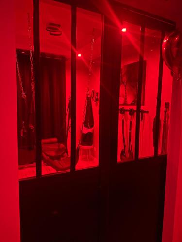 Zimmer mit roter Beleuchtung und einem Zimmer mit Stuhl in der Unterkunft La Maison des Plaisirs Love room in Champigny-sur-Yonne