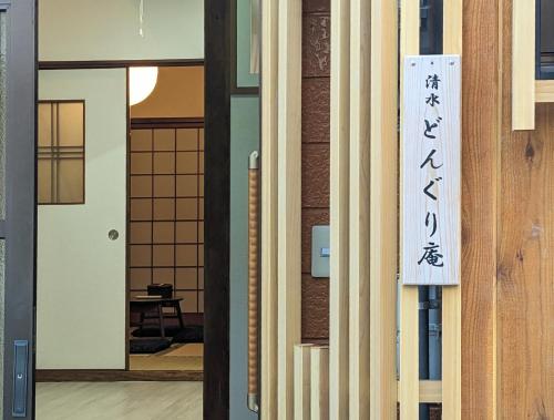 a door with a sign on the side of a building at Kiyomizu Donguri An in Kyoto
