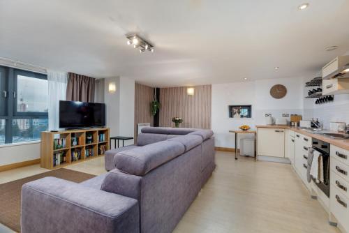 a living room with a couch and a kitchen at Urban Oasis: Heart of City by Train in Leeds