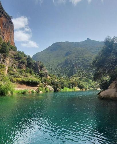 a river with green mountains in the background at Maison d'Hôtes Akchour in Chefchaouene