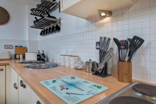 a kitchen counter with a sink and utensils at Urban Oasis: Heart of City by Train in Leeds