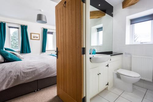 1 dormitorio con cama, lavabo y aseo en Crabtree Barn en Halifax