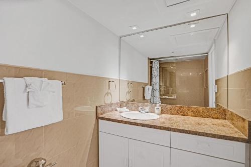 a bathroom with a sink and a mirror at Walk to the Beach Seasonal Vacation Home Pool in Hallandale Beach