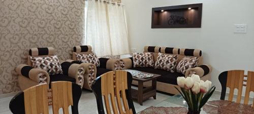 a living room with a couch and chairs and a table at SHI's Vilva AC 2BHK in Coimbatore