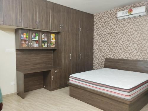 a bedroom with a bed and wooden cabinets at SHI's Vilva AC 2BHK in Coimbatore