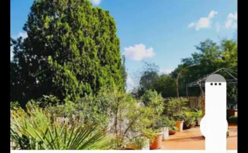 a white lighthouse in a garden with trees and bushes at St peter wiew in Rome