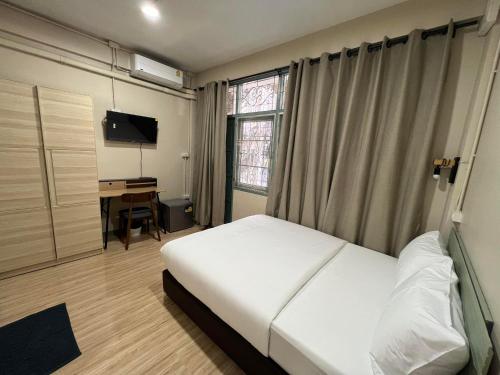a bedroom with a bed and a desk and a window at Bang Wa House - MRT Bang Wa Station in Bangkok