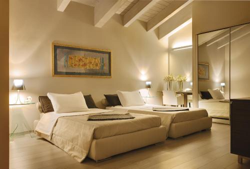 a large bedroom with two beds and a mirror at Hotel Ristorante Sogno in San Felice del Benaco