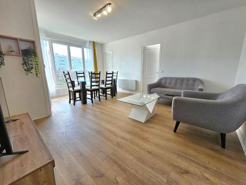 un soggiorno con divano, tavolo e sedie di Charmant appartement proche Paris a Épinay-sur-Seine