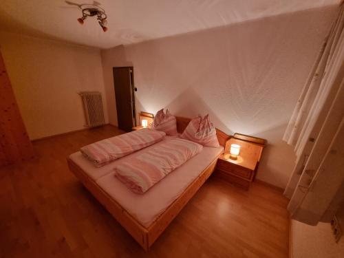 een slaapkamer met een bed met twee lampen erop bij Zettler Apartment in Großsölk