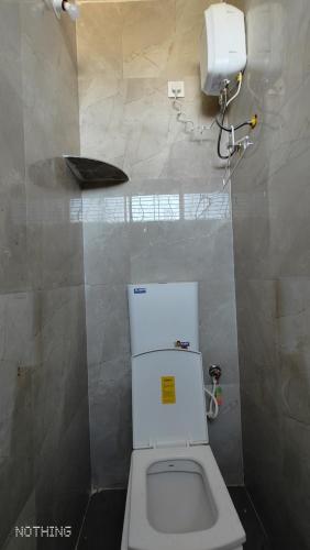 Aadishkti bhakt nivas في Tuljapur: حمام مع مرحاض أبيض في كشك