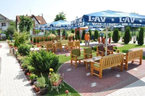 un patio avec des bancs, des tables et des plantes dans l'établissement sporski centar okanik, à Mataruška Banja