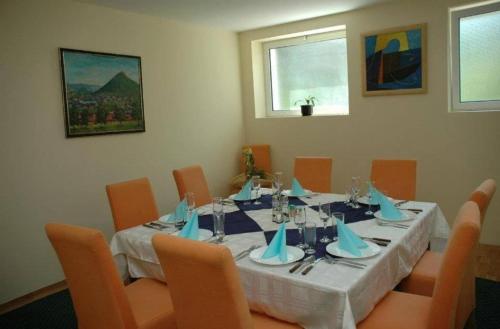 a dining room table with a white table cloth and orange chairs at sporski centar okanik in Mataruška Banja