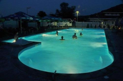 un groupe de personnes dans une piscine la nuit dans l'établissement sporski centar okanik, à Mataruška Banja