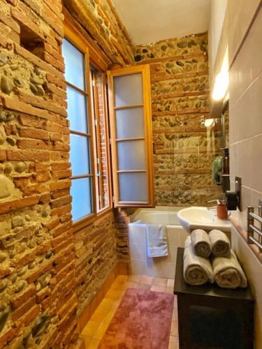 baño con pared de piedra y lavamanos en Cocon cosy dans la ville rose, en Toulouse