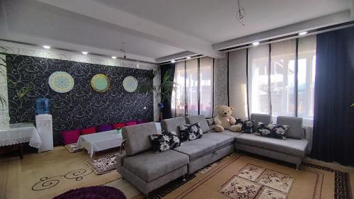 ein Wohnzimmer mit Sofa und Teddybär in der Unterkunft Гостевой дом Datka in Karakol