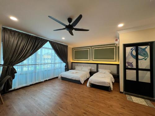 2 camas en una habitación con ventilador de techo en Alia Express Dey Hotel en Kota Bharu