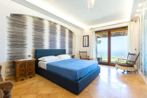 索伦托My Exclusive Italy - Luxury Villa with breathtaking Seaview, pool, BBQ的一间配备有蓝色床的卧室,享有海景