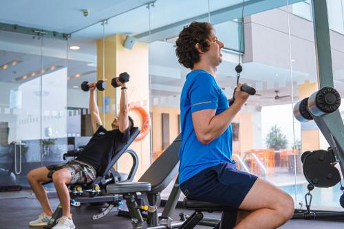 two men exercising in a gym with weights at Holiday Inn Guayaquil Airport by IHG in Guayaquil
