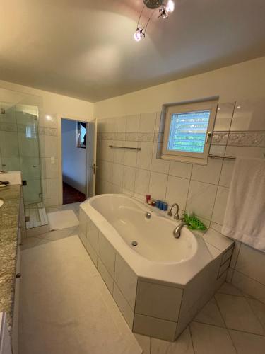a white bathroom with a tub and a window at Spacious and stylish Apartment in Zurich in Zürich