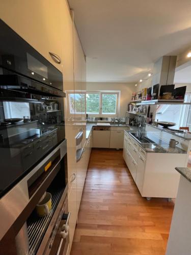 a large kitchen with white appliances and wooden floors at Spacious and stylish Apartment in Zurich in Zürich
